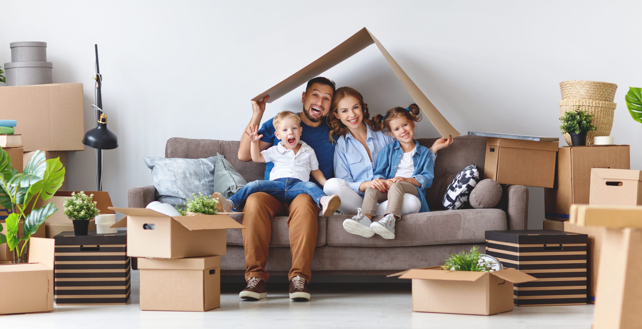 happy family mother father and children move to a new apartment and unpack boxes